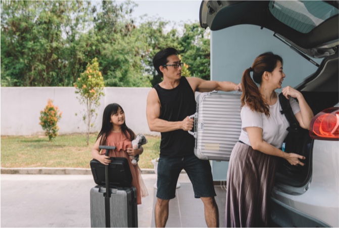 A family placing luggage into a van.