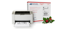 Printer with CNS shipping label in printer tray beside Priority Mail shipping box.