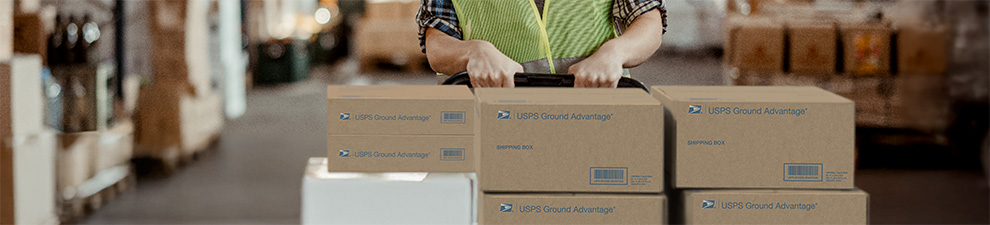 Boxes labeled USPS Ground Advantage being moved in a delivery center.